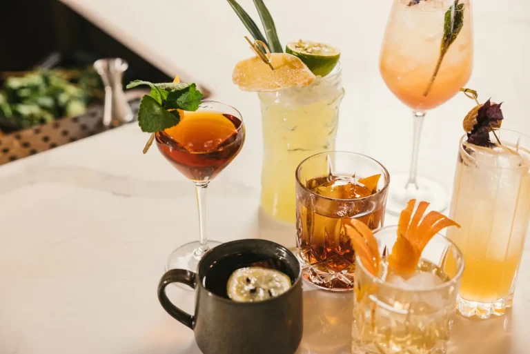 Cocktails and a mug of soup styled together on a bar top