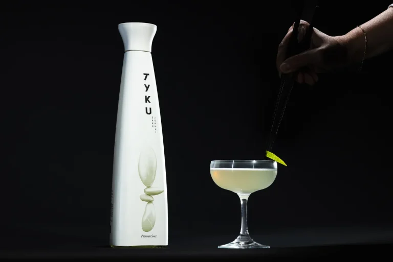 Sake bottle and cocktail on a dark set