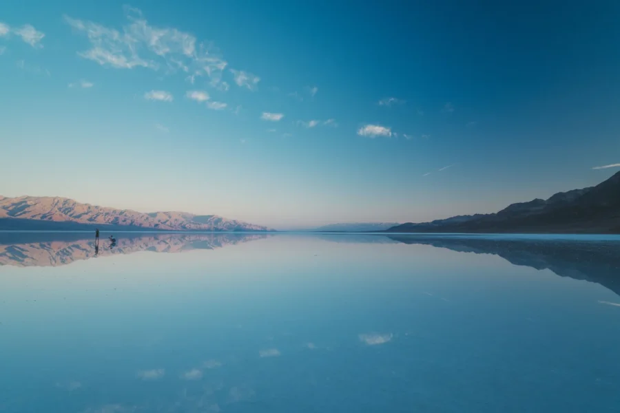 Glassy sunrise reflection on the flooded salt flat at Lake Manly, Badwater Basin, Death Valley
